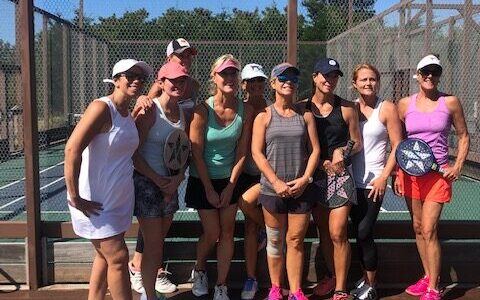 Womens group with paddles on court