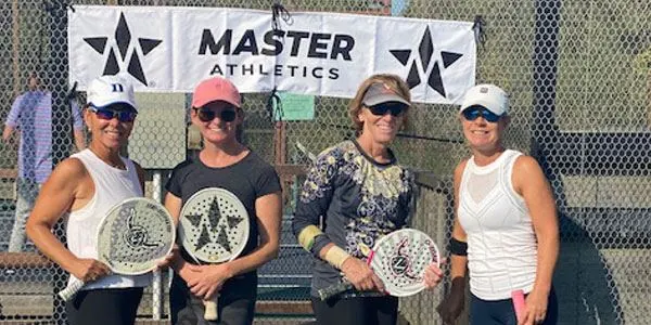 Four campers posing with paddles