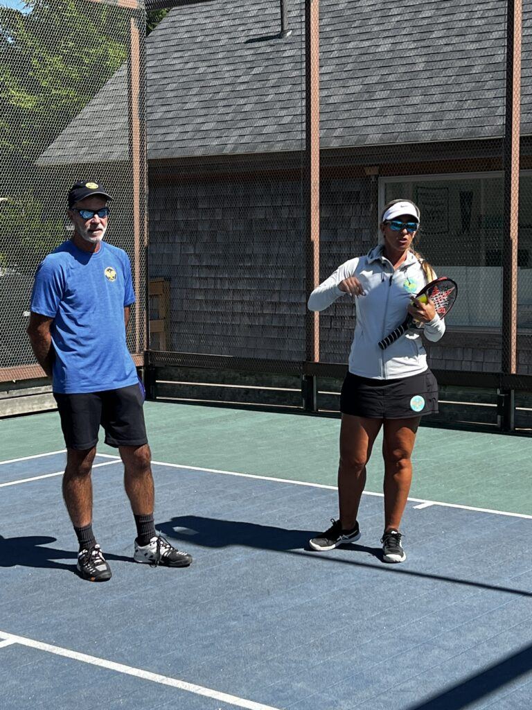 Coaches demonstrating technique on court