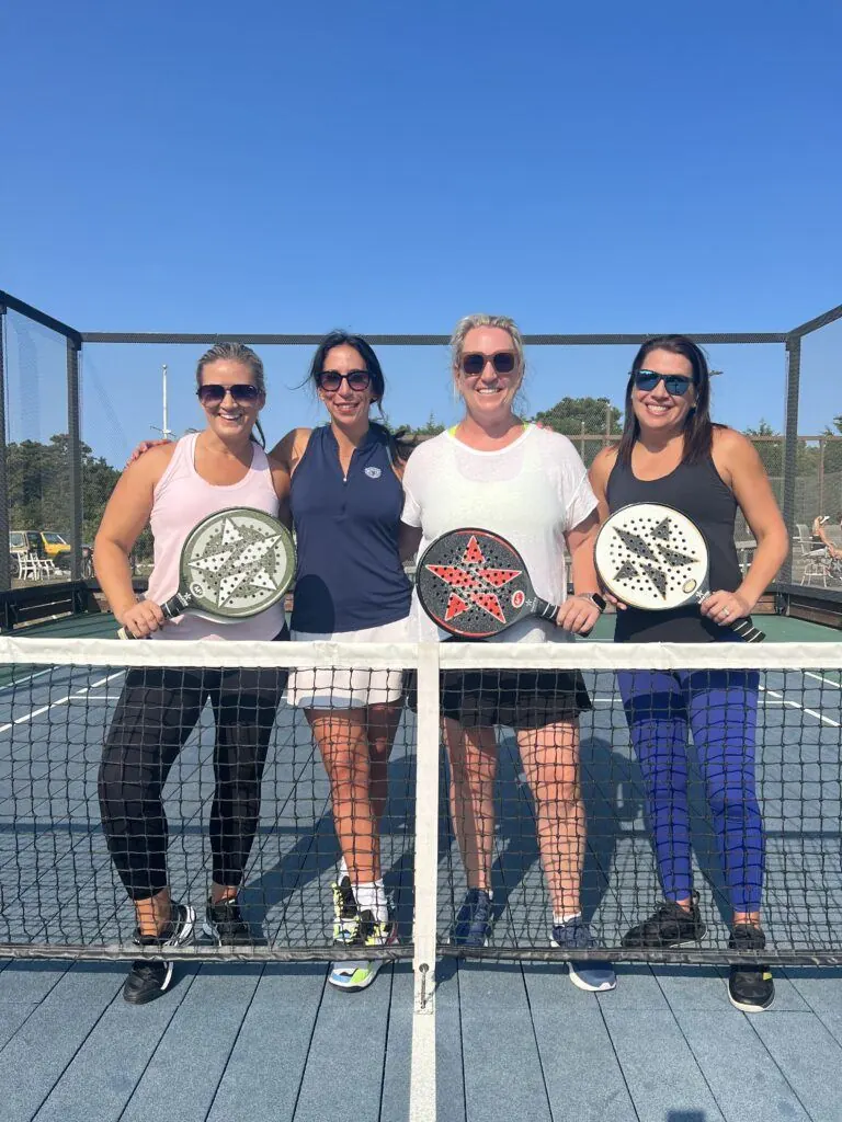 Four campers at the net with paddles