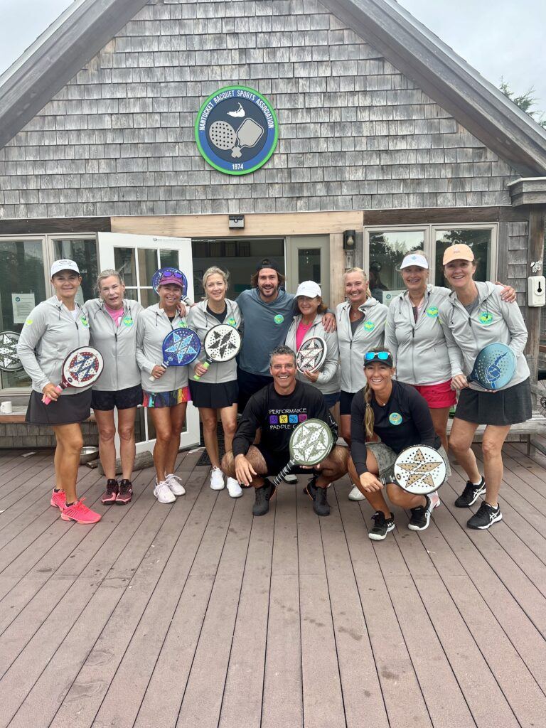 Session group at the NRSA clubhouse with paddles