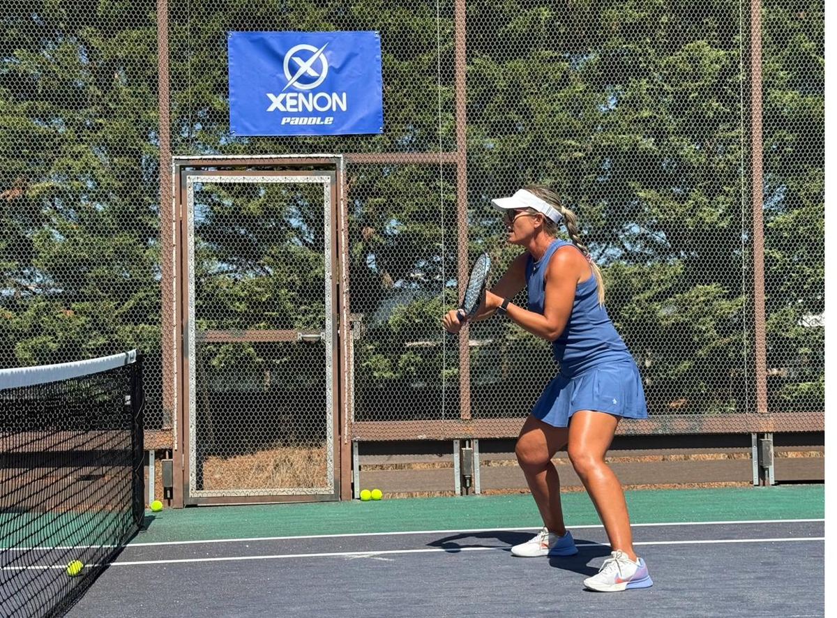Coach preparing backhand return on court