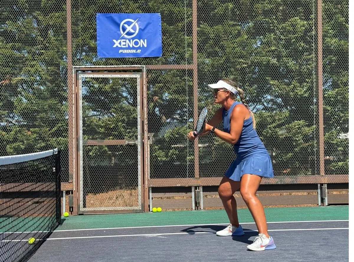 Coach preparing backhand return on court